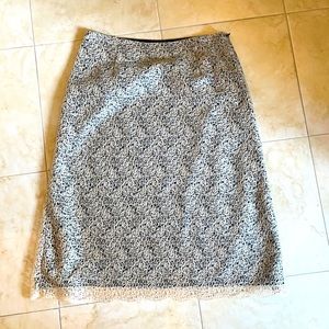 Very cool soft lace like material lays beautifully over black skirt